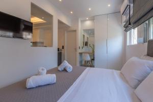 sypialnia z dużym białym łóżkiem z ręcznikami w obiekcie Mandevilia Suites w Atenach