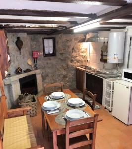 een eetkamer met een tafel en een keuken bij Casa do Barrosinho in Penedones