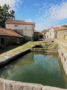 una gran piscina de agua en un patio con edificios en Casa do Barrosinho, en Penedones