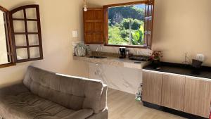 a living room with a couch and a window at Chalés das Acácias in Sana