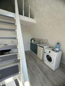 a laundry room with a washing machine and a staircase at Афреем дом in Borovoye