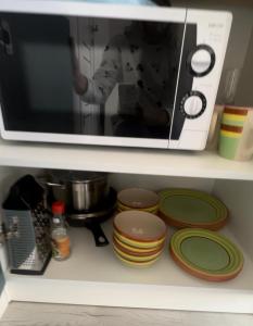 a person is standing behind a microwave on a shelf at Афреем дом in Borovoye