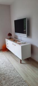 a white cabinet with a television on top of it at Apartament Centrum przy Parku Zdrojowym in Nałęczów