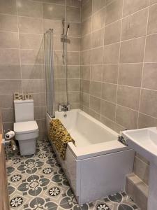 a bathroom with a bath tub and a toilet at Newly Renovated Flat with Free Parking in Walker Gate