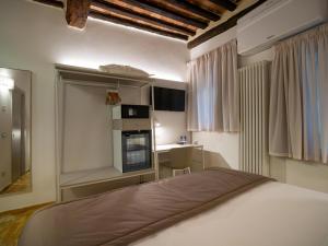 a bedroom with a bed and a kitchen with a stove at Torre del Fuggisole in Siena