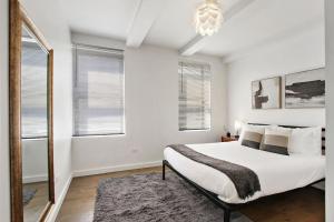 a white bedroom with a large bed and windows at 1BR Prime and Comfy Apt with In-Unit Laundry - Lake 302 in Chicago