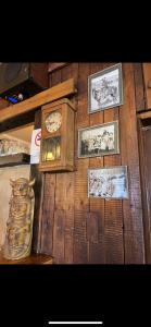 una pared de madera con un reloj y fotos en ella en Texas pub & apartman, en Budapest