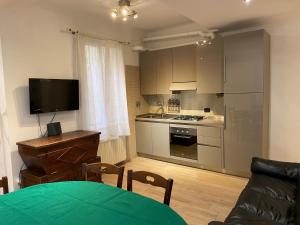 uma sala de estar com uma cozinha com uma mesa e uma televisão em Residenza Santo Stefano 95 - Santo Stefano apartment em Bolonha