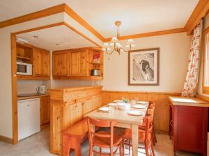 Il comprend une cuisine avec une table et des chaises en bois. dans l'établissement Appartement Valmorel, 3 pièces, 6 personnes - FR-1-291-727, à Valmorel