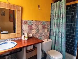 a bathroom with a toilet and a sink and a mirror at Casa La nana de Lorca a 15 min de Granada in Fuente Vaqueros