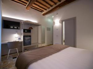 西恩納的住宿－Torre del Fuggisole，一间带一张床和一张书桌的卧室和一间厨房