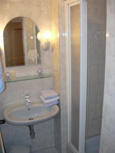 ein Bad mit einem Waschbecken und einer Dusche in der Unterkunft Gästehaus Sams in Gosau