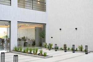 بوابة النخيل للشقق الفندقية في الرياض: مبنى أبيض فيه نباتات في ساحة الفناء