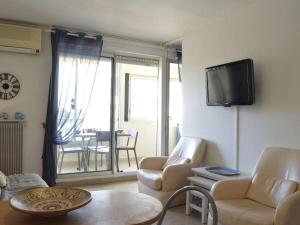 a living room with a couch and a tv on a wall at Appartement Cap d'Agde, 2 pièces, 6 personnes - FR-1-249-127 in Cap d'Agde