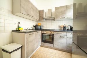 uma cozinha com armários de aço inoxidável e um lavatório em FullHouse - Leonardo Apt - 3 Bedrooms & Balcony em Chemnitz