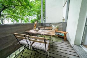 a porch with a wooden table and two chairs at FullHouse - Leonardo Apt - 3 Bedrooms & Balcony in Chemnitz