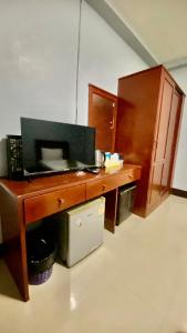 a kitchen with a wooden desk with a microwave at ริเวอร์ไซด์ อพาทเมนต์ in Udon Thani