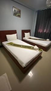 烏隆他尼的住宿－ริเวอร์ไซด์ อพาทเมนต์，配有白色床单的酒店客房内的两张床