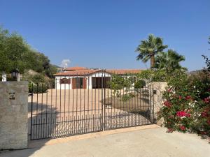 a gate in front of a house with a palm tree at Beautiful Home in Paphos City