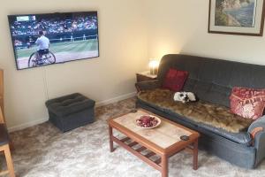 a living room with a dog laying on a couch at Chestnut Lodge Annex in Bridgend