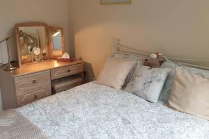 a bedroom with a bed with a dresser and a mirror at Chestnut Lodge Annex in Bridgend