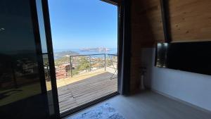 a door to a balcony with a view of the ocean at Ay-Ra Bungalow Suite in Kas