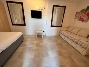 a bedroom with a bed and a tv on the wall at Vivi Vicenza vicino al centro e alla stazione in Vicenza
