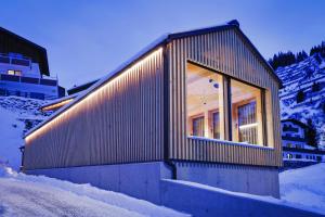 施图本阿尔贝格Frühstückspension Sonnblick的雪覆盖的山顶上的小房子