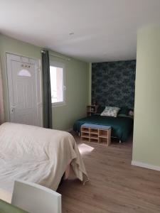 a bedroom with a bed and a couch and a window at Studio J in Oyonnax