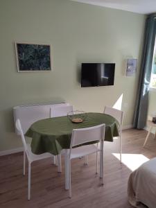 ein Esszimmer mit einem grünen Tisch und Stühlen in der Unterkunft Studio J in Oyonnax
