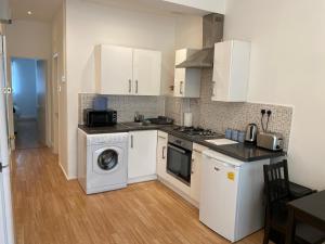 een keuken met een wasmachine en een wasmachine bij The London apartment in Londen