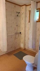 a bathroom with a shower with a toilet and a table at Lyngtun in Viksdalen