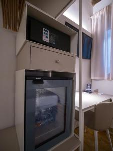 a room with a fireplace with a microwave and a table at Torre del Fuggisole in Siena