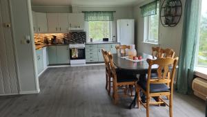 a kitchen with a table and chairs in a kitchen at Lyngtun in Viksdalen