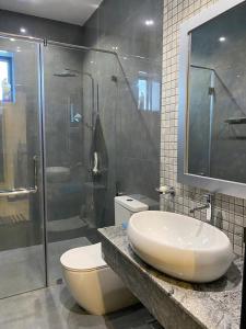 a bathroom with a toilet and a sink and a shower at MercuryFM 105 House Colombo 3 - Schofield pl 3-2 in Colombo