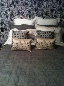 una habitación con un montón de almohadas y una pared en Flat no Hotel Cavalinho Branco, en Águas de Lindóia