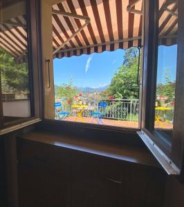 ventana con vistas a una mesa y sillas en Casa Bellavista - Chiara, en Lugano