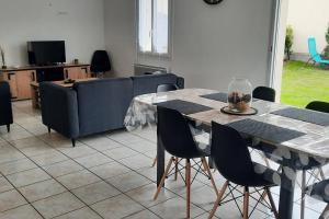a living room with a table and a couch at La Maison LUDO in Arrest