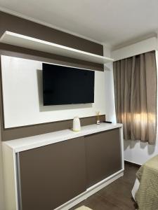 sala de estar con TV de pantalla plana en la pared en SOMBRAS DEL PARANA Apart Misiones en Eldorado