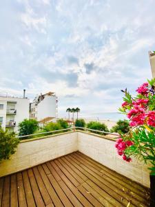 a balcony with a view of the beach and flowers at Increíble casa frente al mar , planta baja in Torredembarra