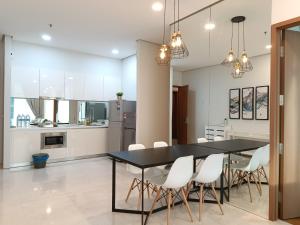 a kitchen and dining room with a black table and white chairs at Soho Suites KLCC by LX Suites 2 in Kuala Lumpur
