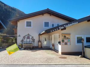 a dog house with a sign in front of it at Das Taubenhaus in Hollersbach im Pinzgau