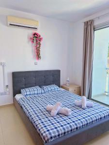 a bedroom with a bed with two slippers on it at 3 Bedroom Coral Bay Beach Seaview Villa II Private Pool in Coral Bay