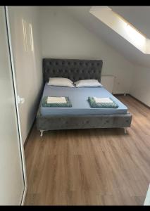 Ce lit se trouve dans une petite chambre dotée de parquet. dans l'établissement Bella apartmani, à Požarevac