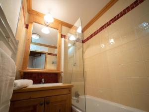 uma casa de banho com um chuveiro, um lavatório e um espelho. em Appartement Valmorel, 4 pièces, 6 personnes - FR-1-291-791 em Valmorel