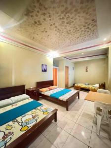 a large room with two beds and tables in it at ASHBURN'S TRANSIENT BAGUIO - BASIC SLEEP and GO, LIMITED PAY PARKING, SELF SERVICE in Baguio