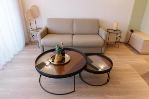 ein Wohnzimmer mit 2 Tischen und einem Sofa in der Unterkunft Résidence Châteauneuf in Menton