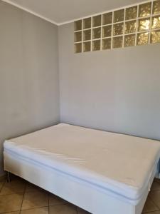 una cama en una esquina de una habitación en Betulle 2G, en Leinì