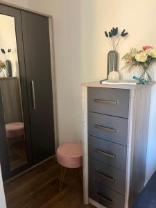 a bedroom with a dresser and a chair and a mirror at Chloes Retreat in Norwich