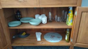 a wooden cabinet with plates and dishes on it at Fair Oak Self-Catering Accomodation in Sandown +35 photos